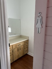 Women's restroom upstairs, behind stage.